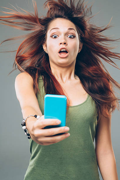 The Girl is Amazed Looking at her Smartphone