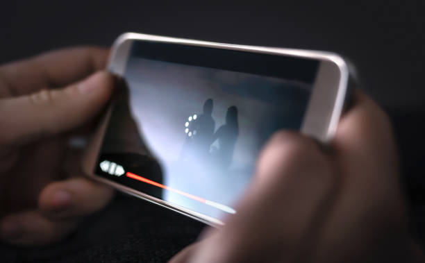 A Person Holding a Smartphone that is Buffering from watching Video