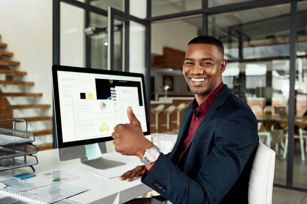 Man with a Thumbs Up sitting in Front of Computer